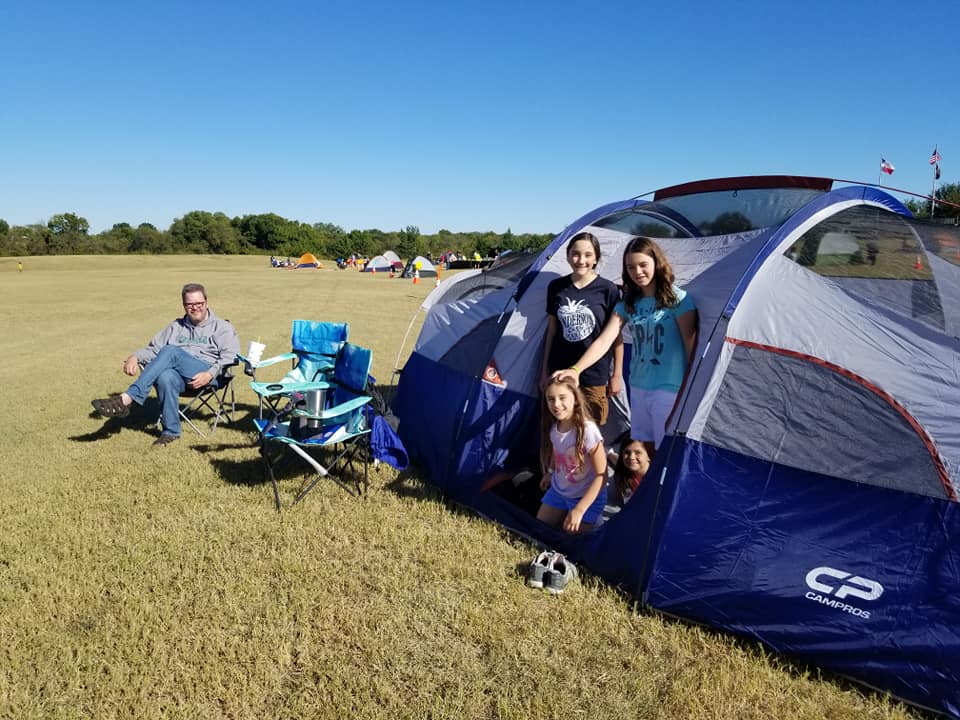 People Sit Next to a 8 person tent