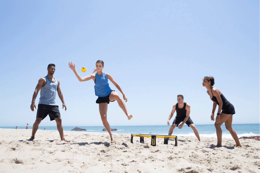 People Play Volleyball While Camping